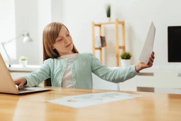 Encantadora chica inteligente hojeando un artículo — Foto de Stock