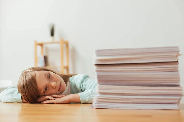Tired diligent student looking at the pile of papers — Stock Photo, Image