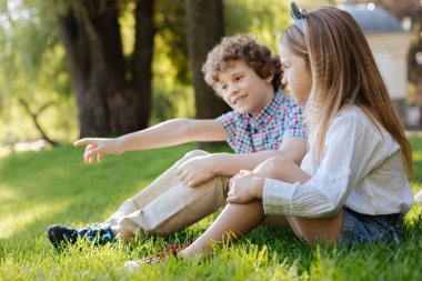 Kıvırcık saçlı bir şeye işaret komik çocuk