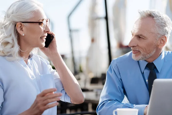 Positive delighted blonde holding telephone near left ear — Stock Photo, Image