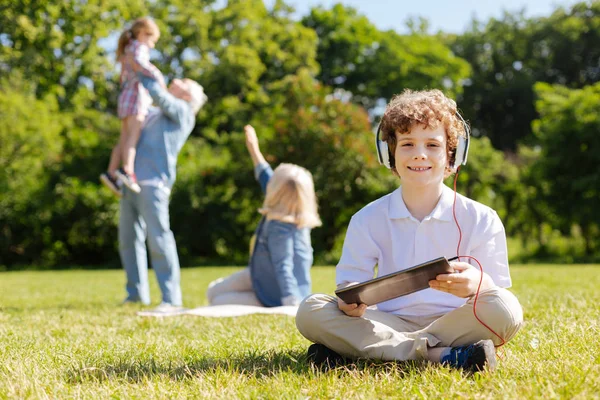 Çimenlerin üzerinde otururken olumlu çocuk geçiş bacaklar