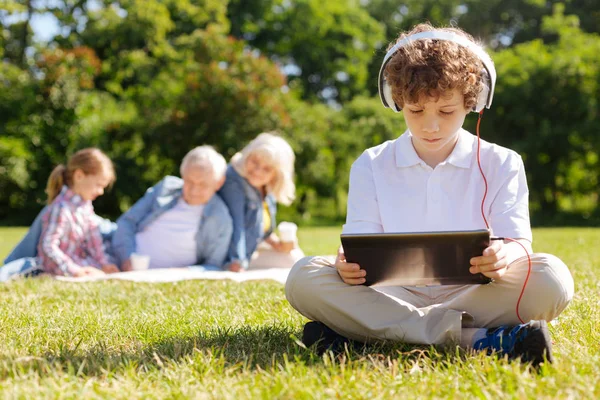 Çok dikkatli çocuk aşağıya doğru tablet üzerinde seyir