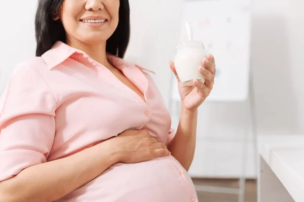 Sorrindo mulher grávida comendo jogurt no escritório — Fotografia de Stock