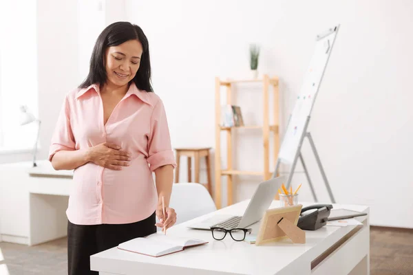 Delighted asian pregnant woman standing in the office — Stock Photo, Image