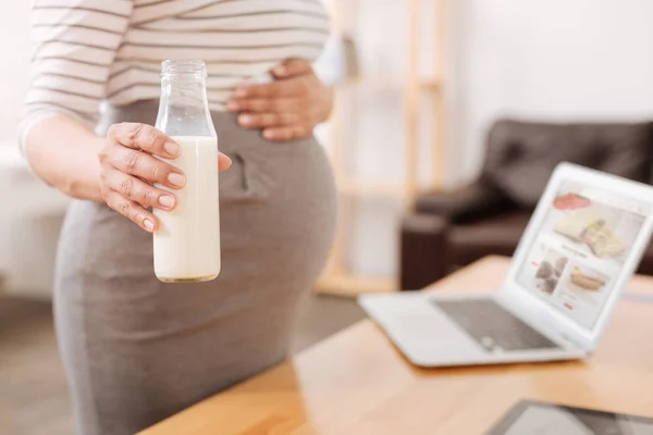 Mulher grávida segurando uma garrafa de leite — Fotografia de Stock