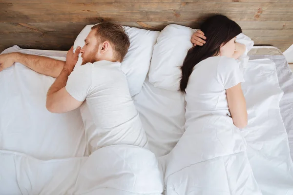 Pareja joven durmiendo tranquilamente en la cama —  Fotos de Stock