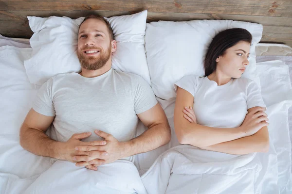 Ευτυχισμένος άνθρωπος και τρελή γυναίκα ξαπλωμένη στο κρεβάτι μαζί — Φωτογραφία Αρχείου