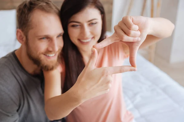 Mujer usando sus dedos para enmarcar caras de pareja —  Fotos de Stock