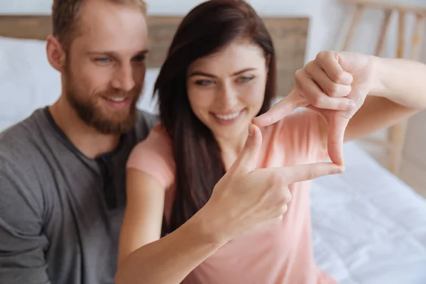 Par har roligt och inramning ansikten med händer — Stockfoto