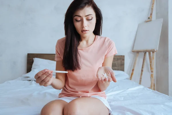 Wanita bingung dengan tes kehamilan dan pil — Stok Foto