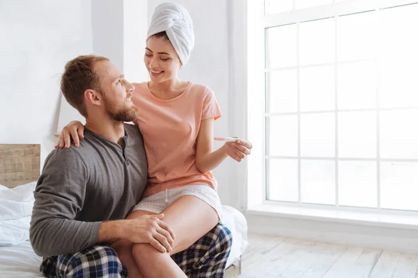 Feliz embarazada sentada en los maridos regazo — Foto de Stock