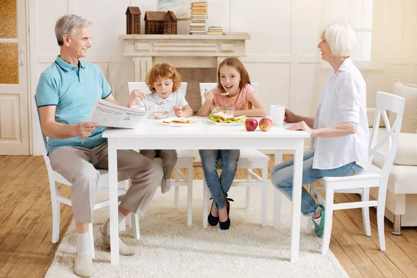 祖父母と朝食を楽しむ魅力的な興奮して子どもたち — ストック写真