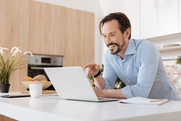 Hombre alegre riendo mientras mira el portátil — Foto de Stock