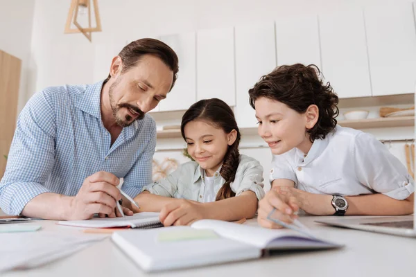 Padre joven ayudando a sus hijos con tareas matemáticas — Foto de Stock