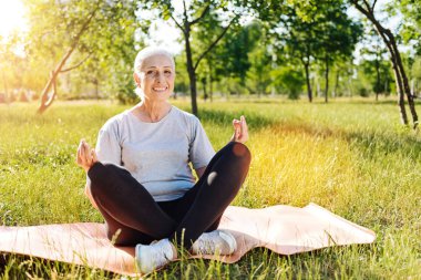 Kadın parkta yoga yapıyor.