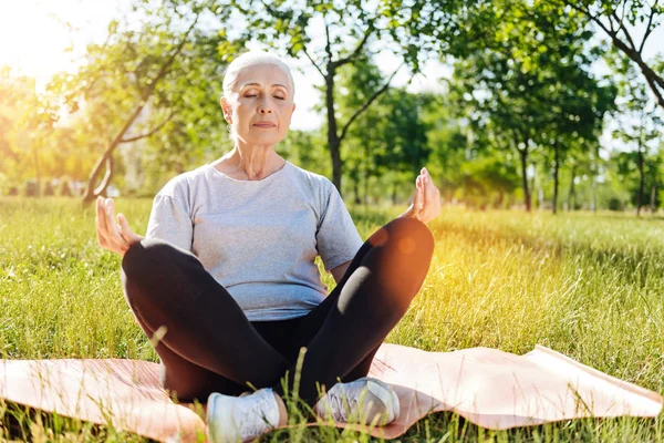 Betagte Frau praktiziert Yoga im Park — Stockfoto