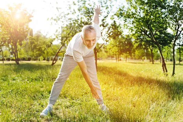 Веселый пожилой мужчина наслаждается спортивными упражнениями — стоковое фото