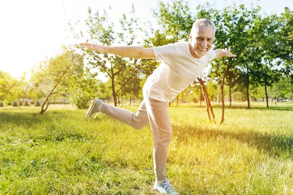 Веселый пожилой человек наслаждается спортивными упражнениями — стоковое фото
