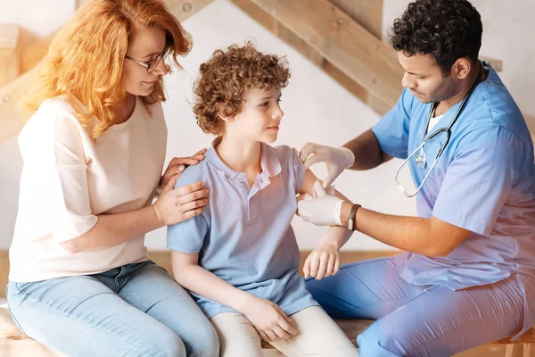 Rustige jongen geven zijn arm naar de dokter — Stockfoto