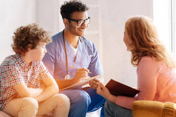 Sorridente medico consulente madre del suo paziente — Foto Stock