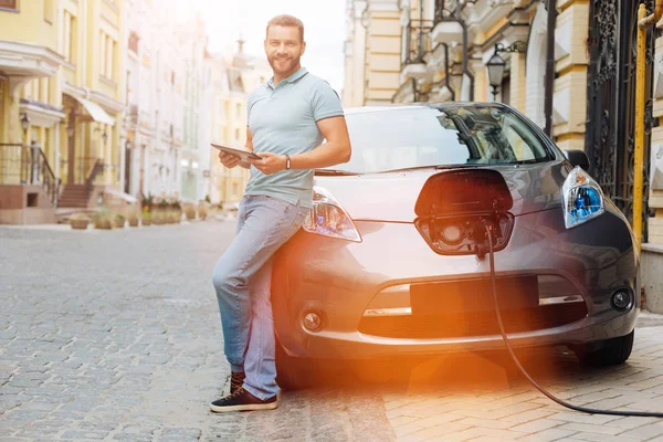 Young man waiting his car to be charged — Stock Photo, Image