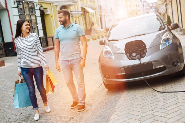 Pareja alegre caminando por la calle después de ir de compras —  Fotos de Stock