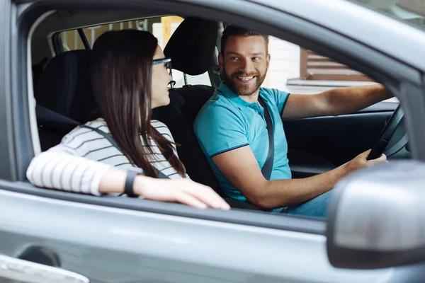 Pareja feliz sentada en su coche nuevo — Foto de Stock