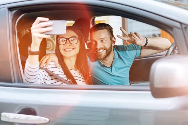 Schönes junges Paar macht Selfies im Auto — Stockfoto