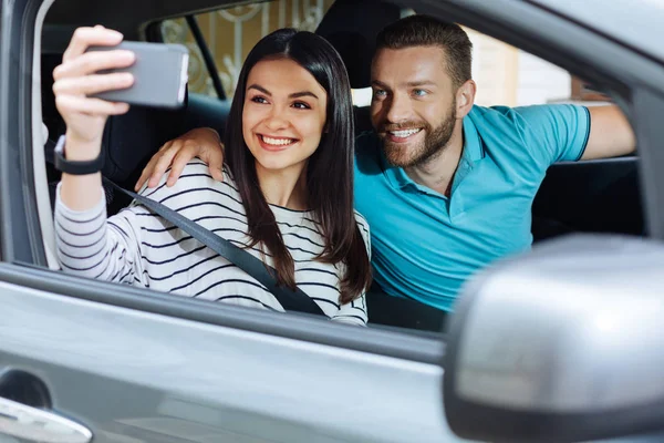 Charming young couple taking pictures of themselves