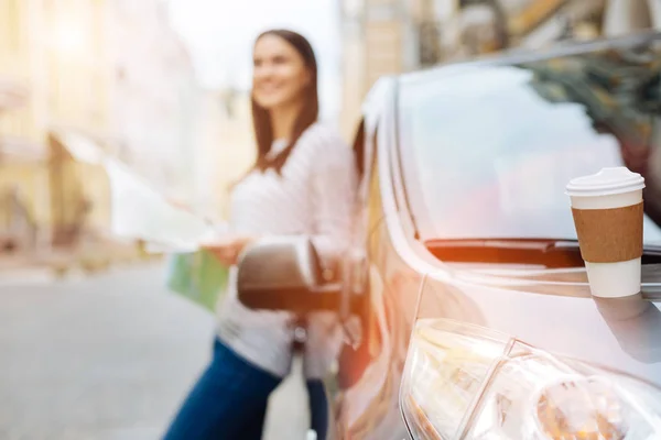 Witte koffie kopje staande op de motorkap van de auto — Stockfoto