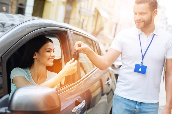 Empleado de la agencia de alquiler de coches dando llaves de coche a la mujer —  Fotos de Stock