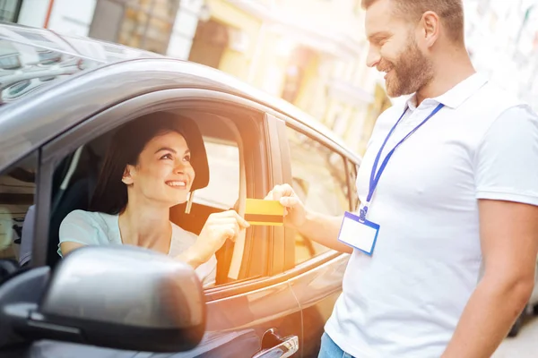 Bil uthyrning arbetstagaren tar emot kreditkort — Stockfoto