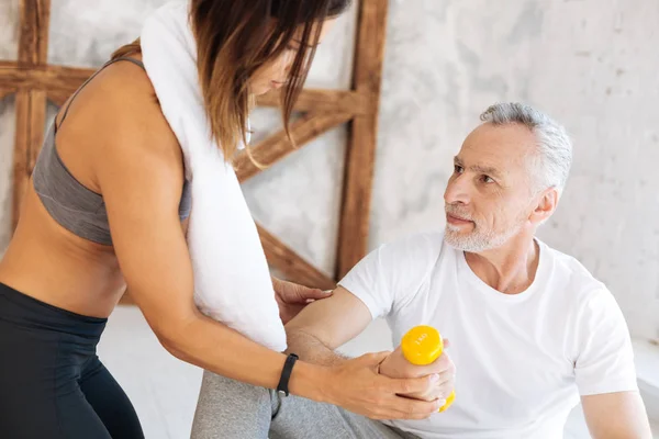 Atento morena ayudando a levantar el brazo correctamente — Foto de Stock