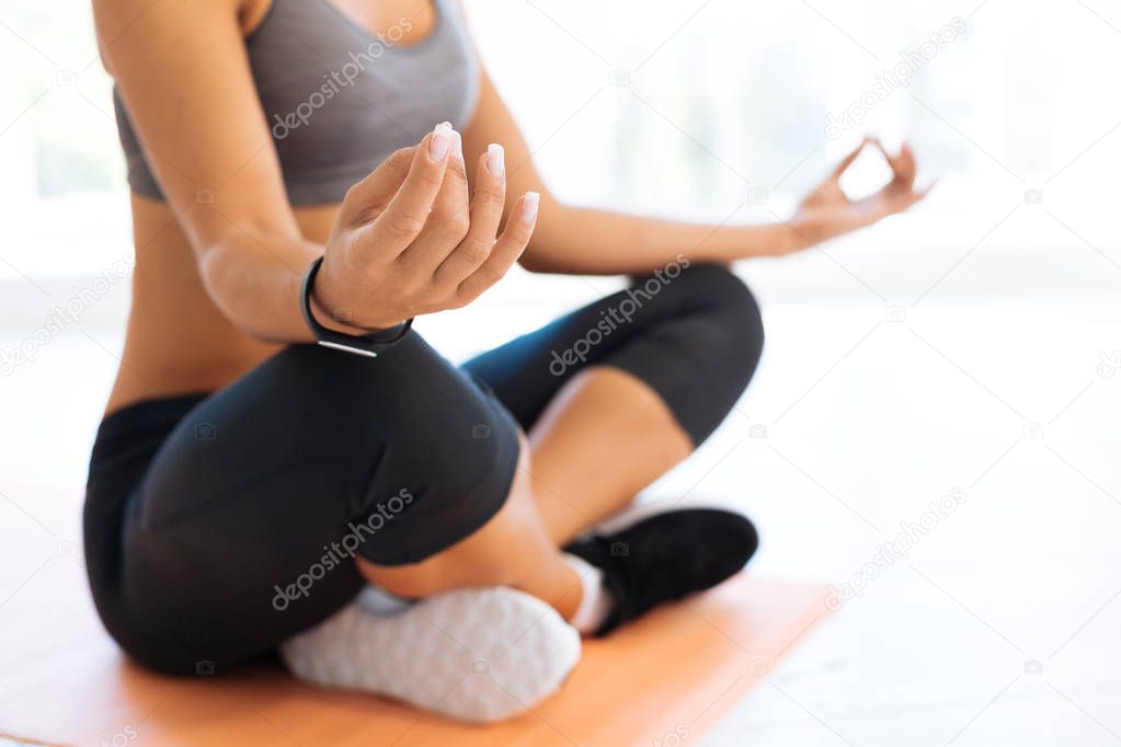 Healthy woman sitting on the floor while meditating