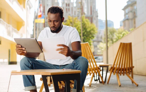 Escrupuloso hombre de negocios analítico comparando números — Foto de Stock