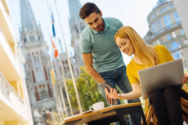 Easygoing mooie vrouw toont haar vriend een bericht — Stockfoto