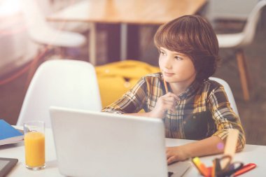 Laptop oturan düşünceli güzel çocuk