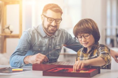 Satranç tahtası üzerinde satranç taşları koyarak çok mutlu mutlu adam