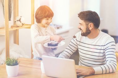 Babası bir pasta sunan pozitif mutlu çocuk