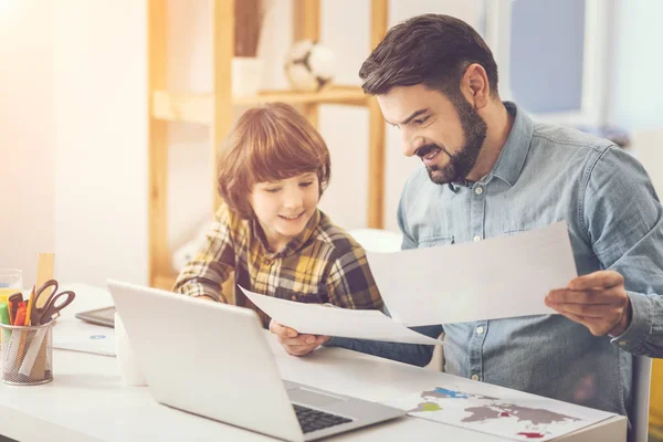 Pleasant caring father helping his son with school homework — Stock Photo, Image
