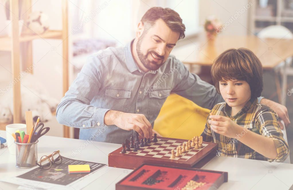 Cute smart boy learning to play chess