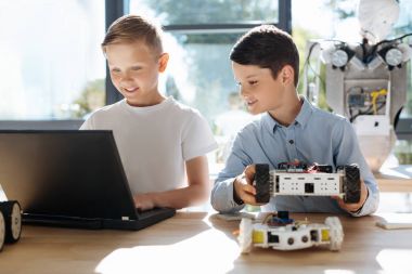 Neşeli çocuk onun arkadaş programı bir robot araç izlerken