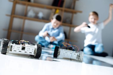 Robot araba yarışı oynayan küçük çocuklar