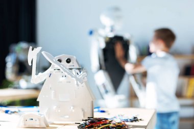 Beyaz robot oyuncak ayakta masaya