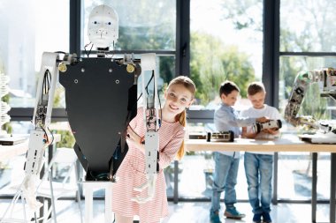Çekici kız bir insan robot arkasından poz