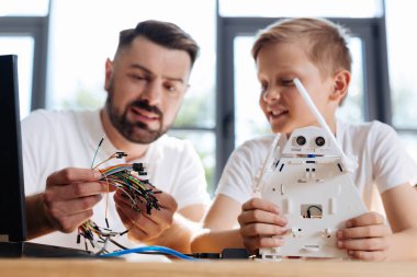 Genç öğretmen öğrencisini robot inşaat ile yardım