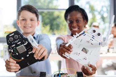 Çocuk kameraya gülümseyen robot modelleri ile
