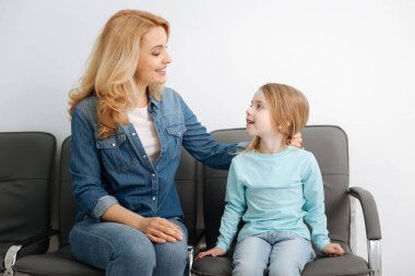 Kızıyla birlikte salonda oturmuş güzel anne