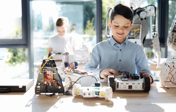 Robot araç ön kısmını inceleyerek çocuk