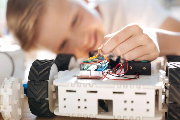 Little boy holding wires of robotic vehicle — Stock Photo, Image